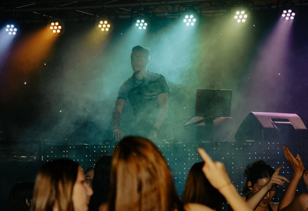 Feiernde Menschen mit DJ und Lichtshow